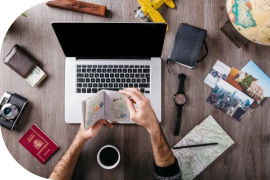 Travel planning with a passport, map and laptop